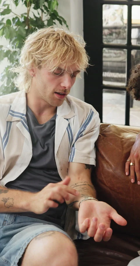 Talking, friends and men on sofa to explain tattoos, conversation and hangout in Stock Footage 329376590