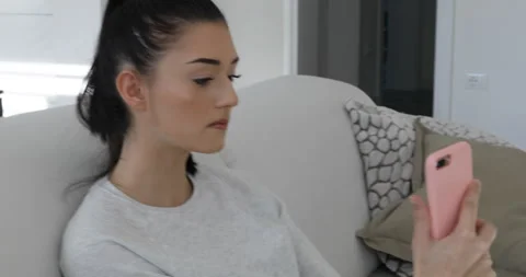 Talking on my sofa using a pink smartphone Stock Footage 154085018
