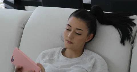 Talking on my sofa using a pink smartphone Stock Footage 154085421