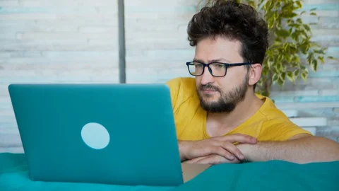 Talking online, hipster is having a conversation with a friend. The guy is Stock Footage 129821789