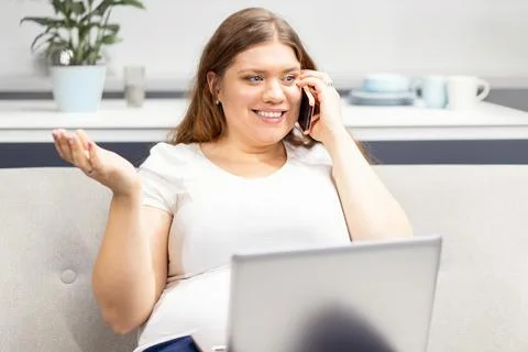 Talking on the phone with nutritionist looking at the program on a laptop young Foto stock