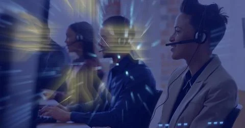 Talking right rep wearing light blazer with headset at call center, monitors, Stock Photos