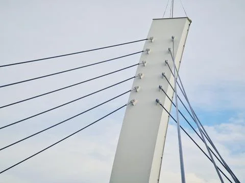 Tall angled bridge pylon with multiple steel cables radiating outward, set ag Stock-Fotos