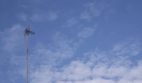 Tall Antenna Pole Under Cloudy Blue Sky Background Stock Photos