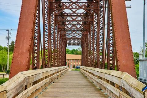 Tall beams reaching up from old rusty railroad bridge converted into wooden 스톡 사진