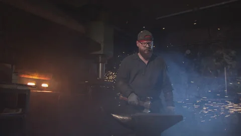 Tall bearded blacksmith at workplace Video stock 146461571