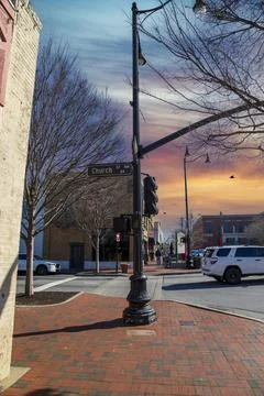 A tall black light posts on a red brick sidewalk on the corner of Church St.. Fotos de archivo