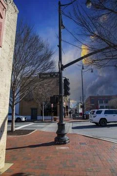 A tall black light posts on a red brick sidewalk on the corner of Church St.. Fotos de archivo