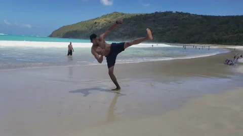 Tall Black Man Practicing Martial Arts Tricking at Beach Stock Footage 146559446
