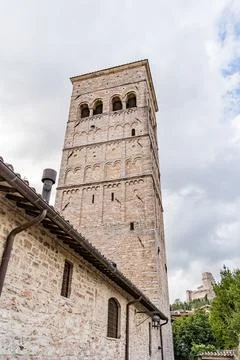 A tall brick tower with a clock on the side in Assisi city in Italy Umbria Foto stock