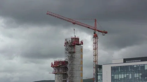 Tall building construction crane workers  zoom in Stock Footage 74184972