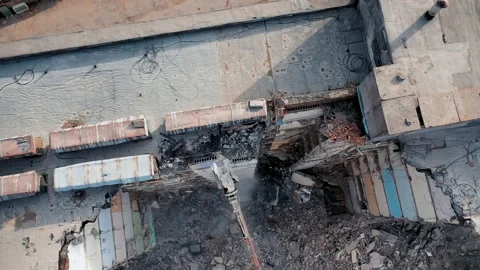 Tall building destroyed. Demolition machine tearing down roof of a wrecked build Stock-Footage 198813661