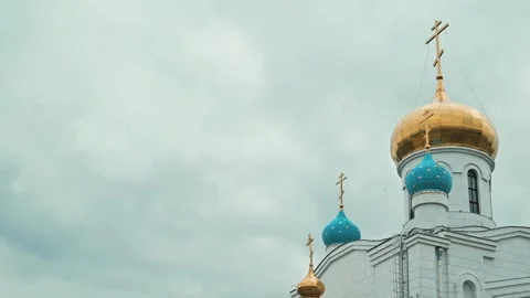 A tall building features golden domes and blue peaks surrounded by clouds. The Stock Footage 339094334
