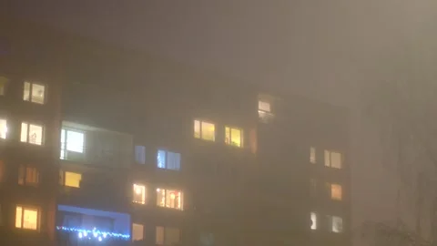 A tall building featuring a large number of windows shines brightly when illumin Vídeos de archivo 297200060