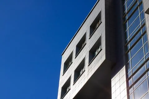 A tall building featuring numerous windows set against a clear blue sky Fotos de archivo