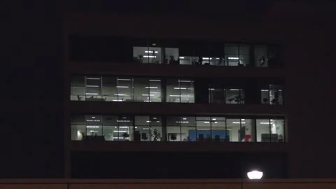 A tall building with many windows lit up at night 스톡 동영상 328992797