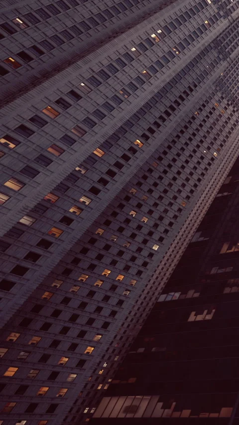 Tall building with windows glowing in city at dusk time Stock Footage 342170032