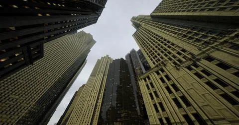 Tall buildings captured from a low angle in an urban setting with cloudy sky Ilustración de archivo