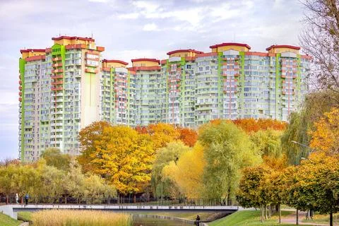 Tall buildings stand in the background while trees show fall colors near a .. 写真素材