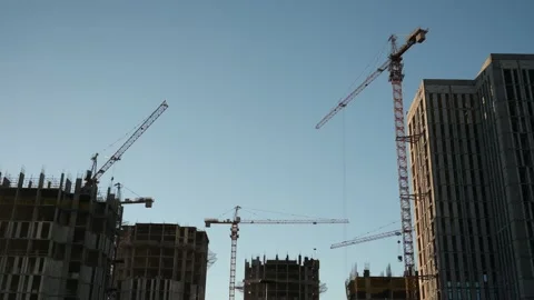 Tall buildings under construction and cranes under a blue sky Stock Footage 228012677