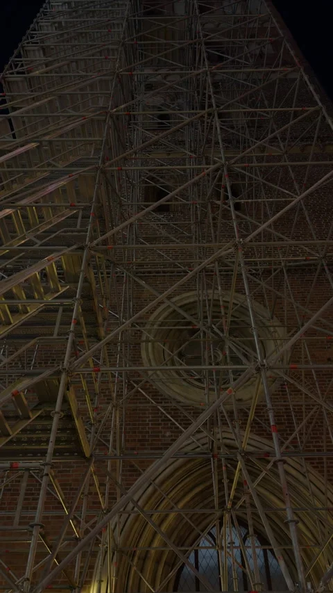 Tall cathedral facade covered with dense scaffolding and stone arches during Stock Footage 346734495