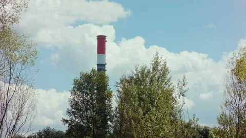 Tall Chimney Pipe Behind Trees with Blue Sky and Clouds Stock Footage 135389976