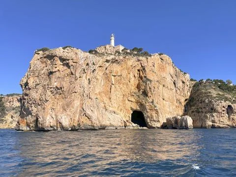 Tall cliff with lighthouse at Cape Sant Antoni near Javea, Spain Stock Photos