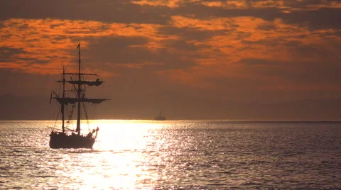 A tall clipper ship sails at sunset with sailors on the riggings. Stock Footage 55513290