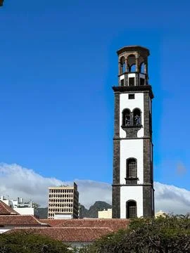 Tall clock tower with blue sky and city buildings Stock Photos