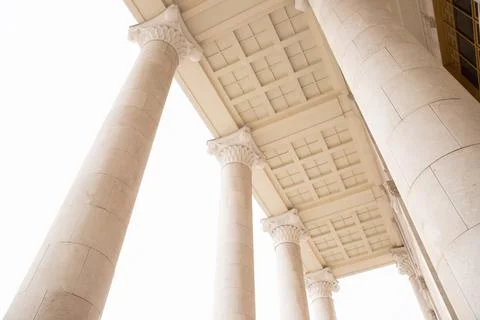 Tall columns on white rain clouds background, entrance to building Stock Photos