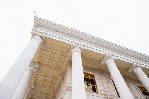 Tall columns on white rain clouds background, entrance to building 스톡 사진