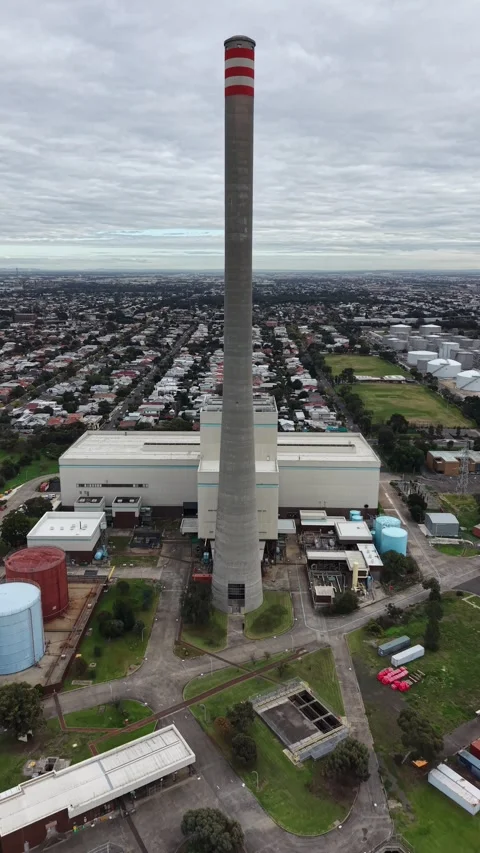 Tall concrete chimney stack rising over industrial power plant Stock Footage 337810924