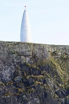 A tall, conical structure, painted white with a red orb at its apex 库存照片