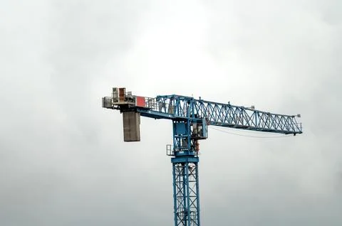 Tall construction crane against a cloudy sky. Clear background. Stock Photos