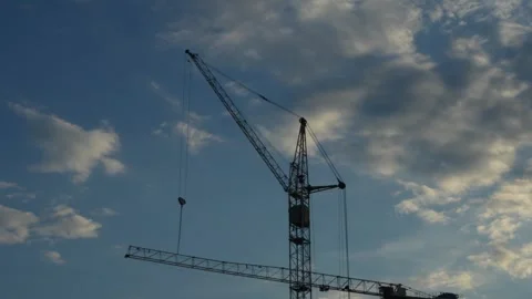 A tall construction crane stands against a cloudy blue sky. Stock Footage 341689305
