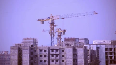 Tall construction crane tower moving working at under construction building site Stock Footage 135676420