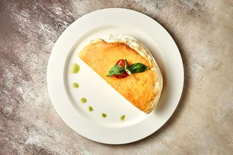 A tall egg omelet with lettuce on a white plate. Selective focus. Noise in po Stock Photos