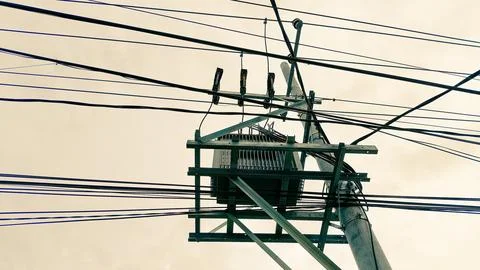 Tall electricity tower structure under cloudy skies, representing power, in.. Stock Photos