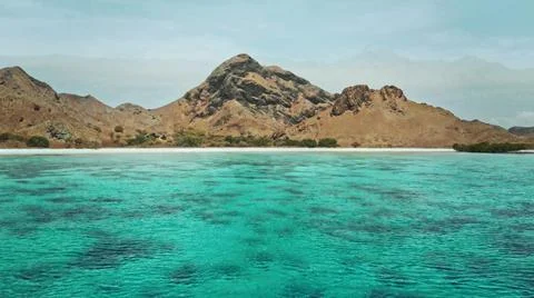 The tall elephant cliffs blocking the waves are covered with green trees and  Foto stock