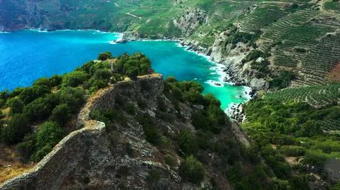 The tall elephant cliffs blocking the waves are covered with green trees and  Stock Photos