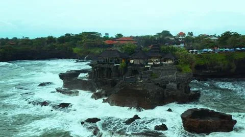 The tall elephant cliffs blocking the waves are covered with green trees and  Foto stock