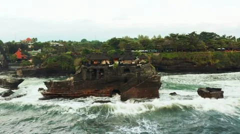 The tall elephant cliffs blocking the waves are covered with green trees and  Stock Photos