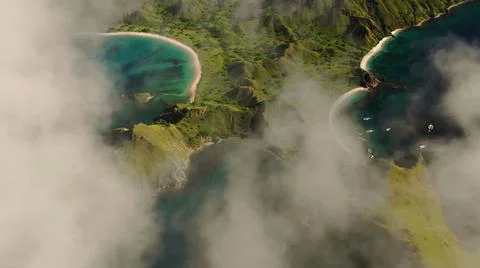The tall elephant cliffs blocking the waves are covered with green trees and  Stock Photos