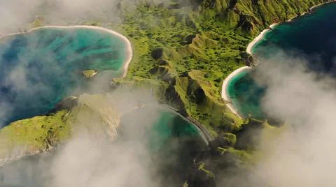 The tall elephant cliffs blocking the waves are covered with green trees and  Stock Photos