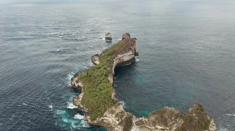 The tall elephant cliffs blocking the waves are covered with green trees and  Foto stock