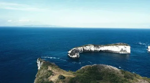 The tall elephant cliffs blocking the waves are covered with green trees and  Stock Photos