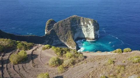 The tall elephant cliffs blocking the waves are covered with green trees and  Stock Photos