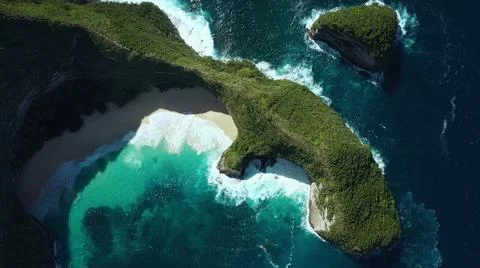 The tall elephant cliffs blocking the waves are covered with green trees and  Stock Photos