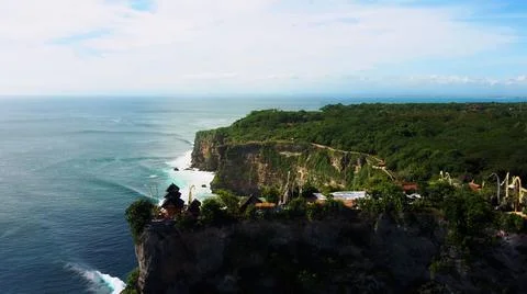 The tall elephant cliffs blocking the waves are covered with green trees and  Foto stock