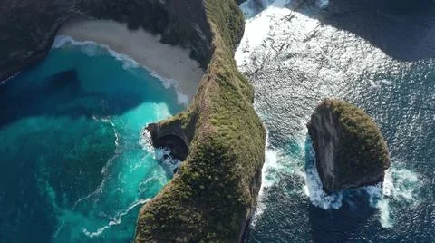 The tall elephant cliffs blocking the waves are covered with green trees and  Stock Photos